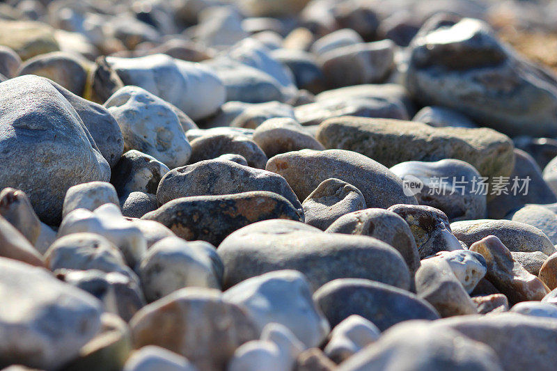 带有不规则灰色卵石/卵石背景的海滨海滩图像
